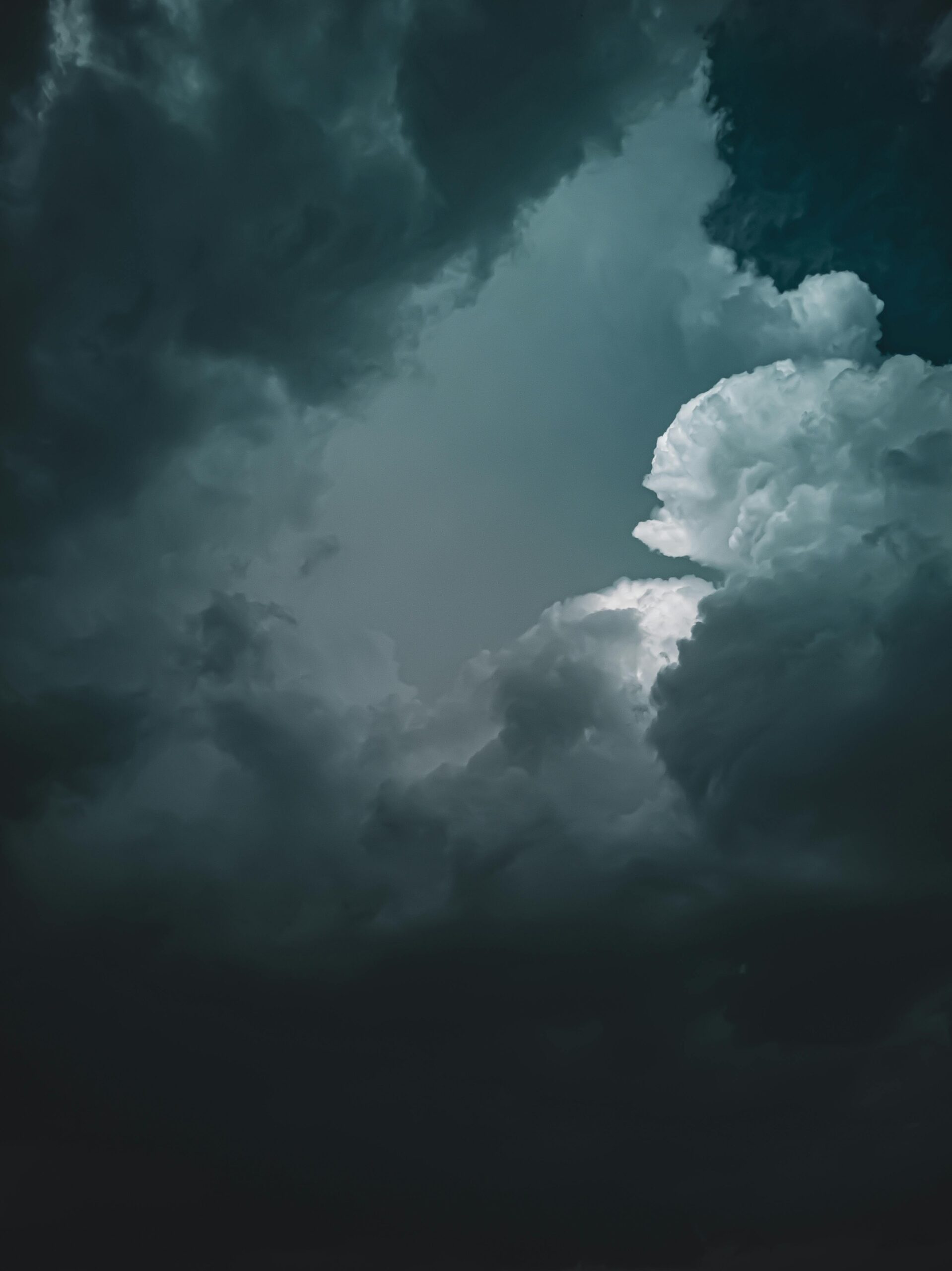 Stunning photograph of dramatic dark clouds forming an overcast sky, creating a moody atmosphere.
